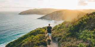 Image of man walking on cliff path